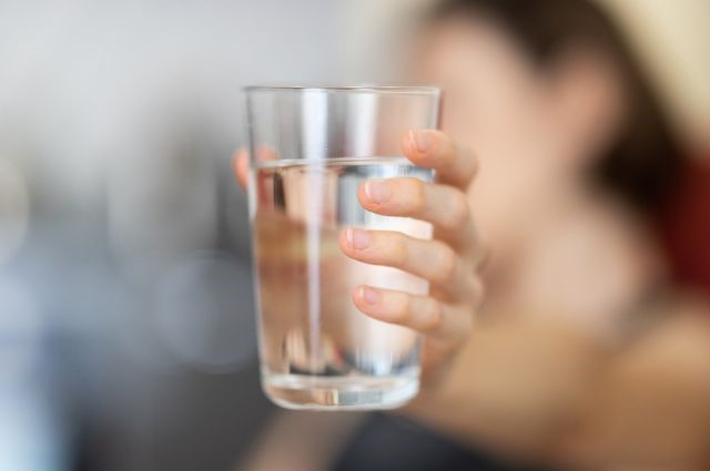 A person holding a glass of water
