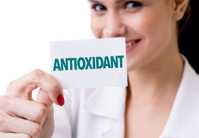 A woman holding a sign that says antioxidant