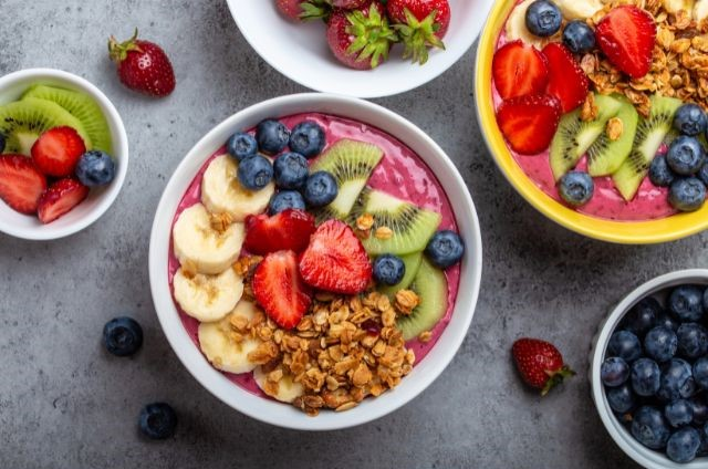 different types of smoothie bowl laying on a grey surface