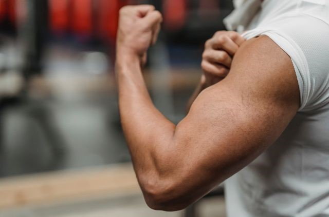 a man flexing his bicep muscles