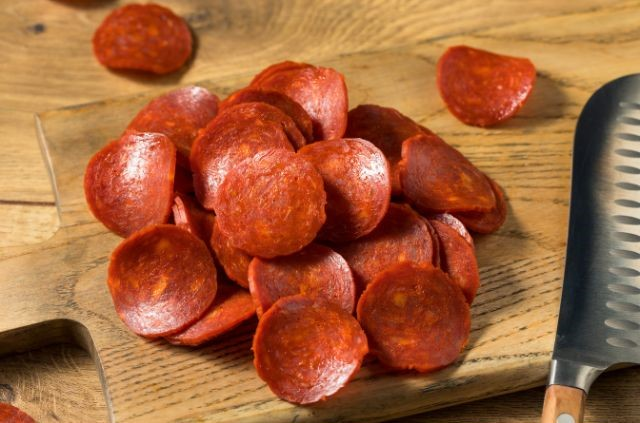 a bunch of pepperoni slices laying on a wooden surface (Is Pepperoni Good For Weight Loss?)