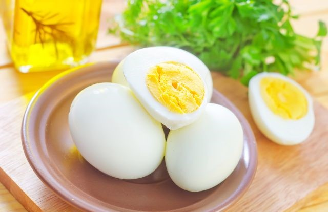 3 boiled eggs laying on a brown dish
