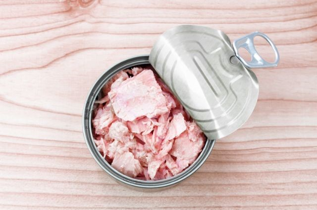 An opened can with meat in it.