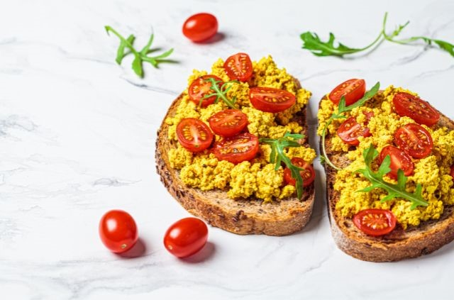 scrambled eggs with tomoatoes on bread slices