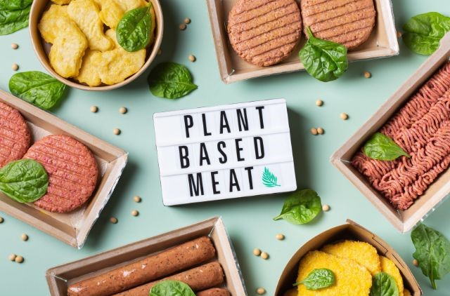 A text saying plant based meat written on a teal green background