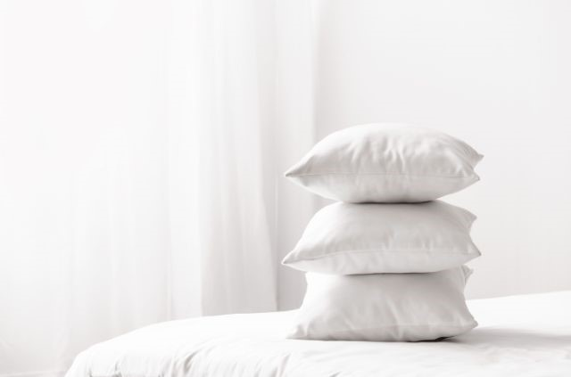 Multiple pillows stacked on a bed
