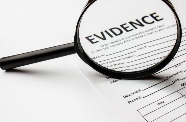 a magnifying glass highlighting the text "evidence" on a paper