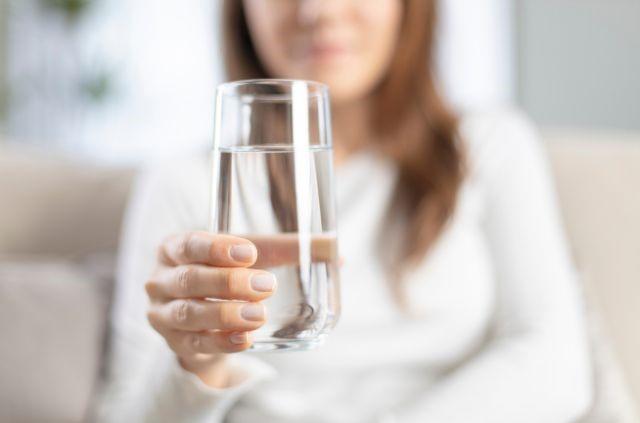 a woman holding a glass of water