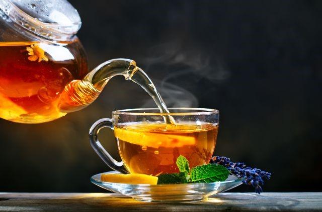 hot tea being poured into a glass cup