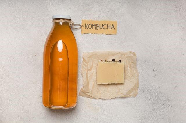 a bottle of kombucha next to a piece of paper (Is Kombucha Good for Weight Loss?)