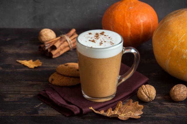 a cup of pumpkin spice latte with whipped cream and nuts