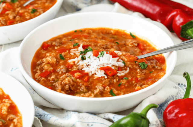 A bowl of stuffed pepper soup with rice, ground meat, and diced vegetables.