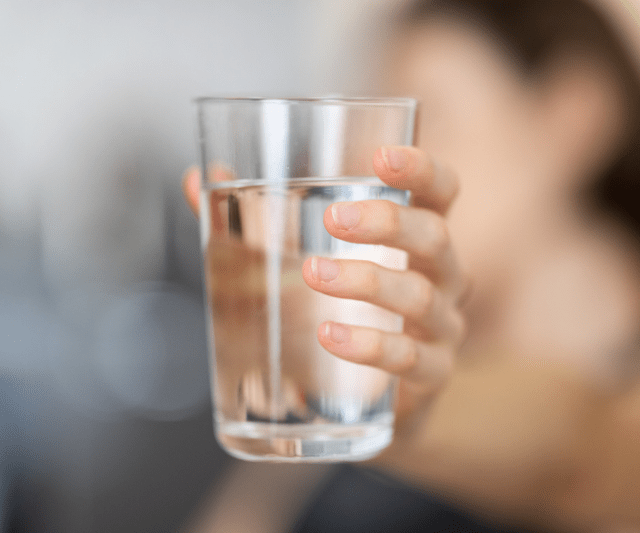 A person holding a glass of water.